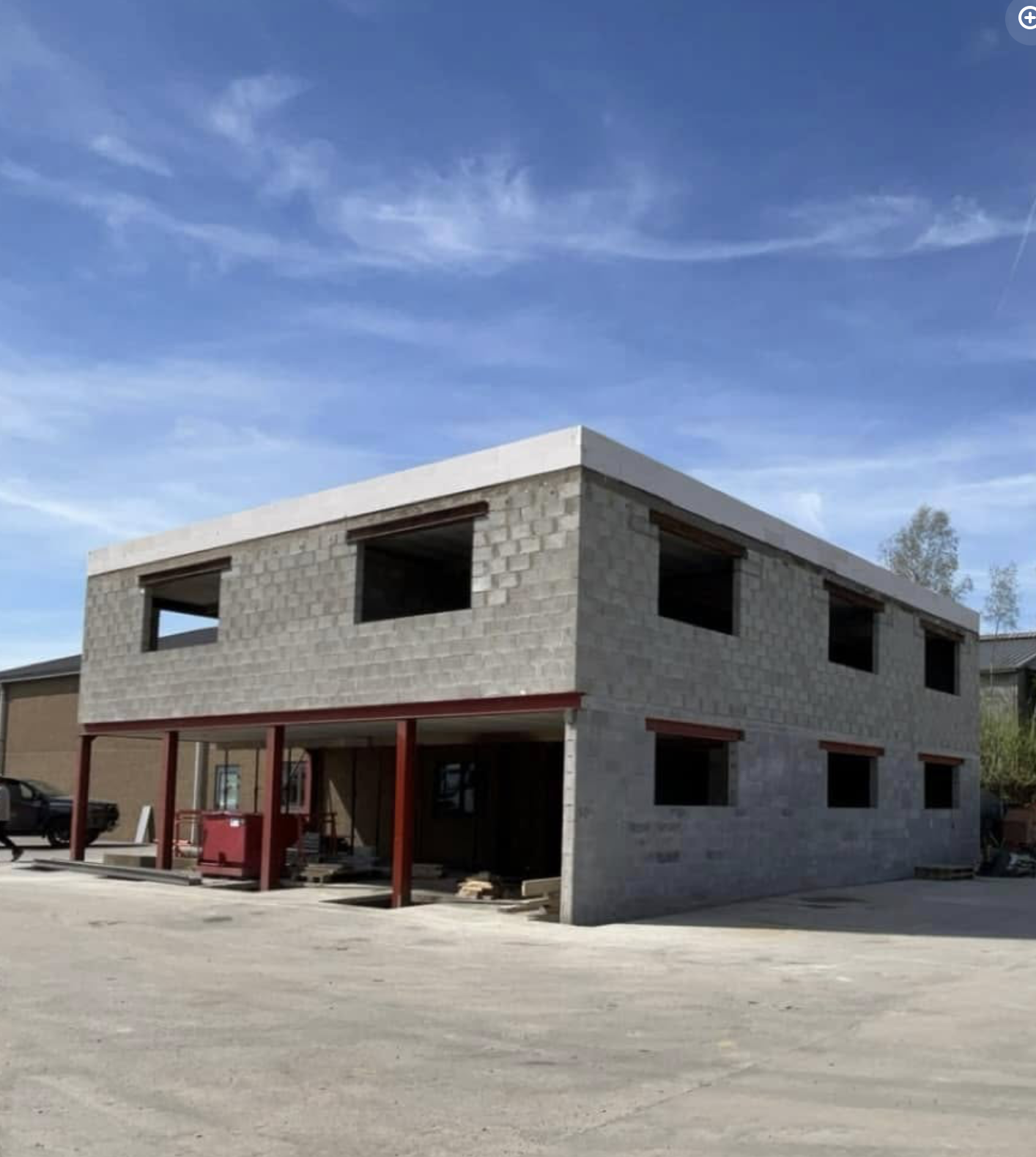 Bâtiment moderne en blocs béton avec poutres rouges